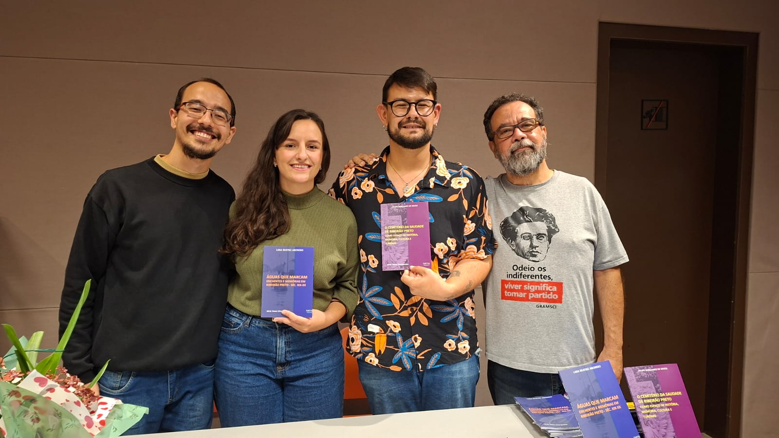 Autores segurando os livros lançados