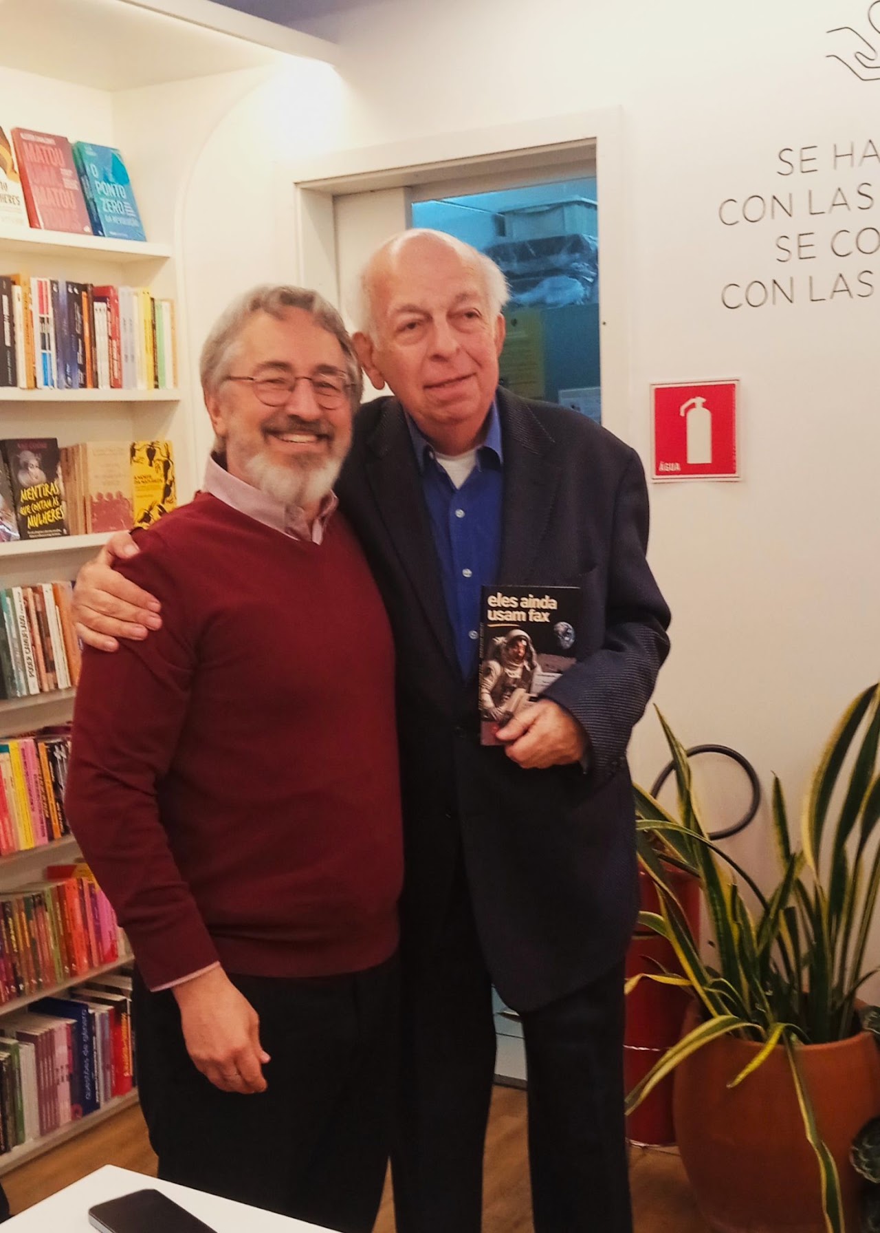 Autor e convidado segurando o livro “Eles ainda usam fax”