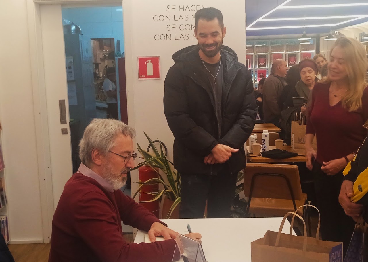 Autor autografando livro para leitor sorridente